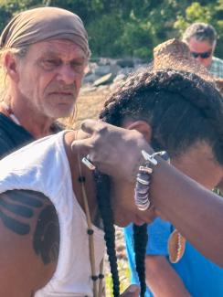 Chenae Bullock gifts Andre Strongheart Bear with a necklace  before Launch. Photo By Reginald L Bullock